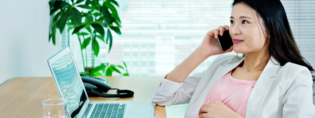 image shows a woman talking on the phone while holding her stomach.