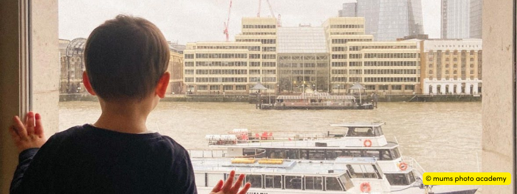 better family photos using your phone - photo shows young boy looking out of a window at a canal. 