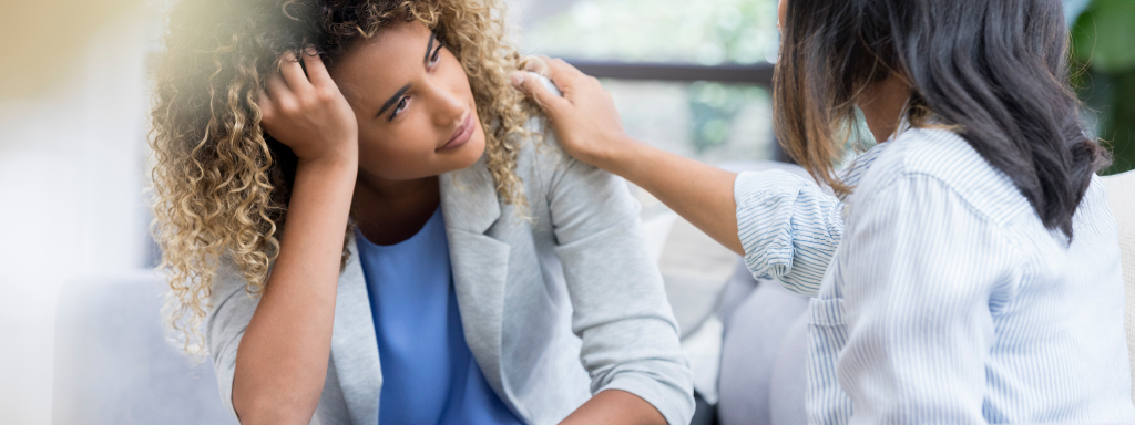 manage intrusive thoughts new parent - the image shows a woman patting another woman on the shoulder