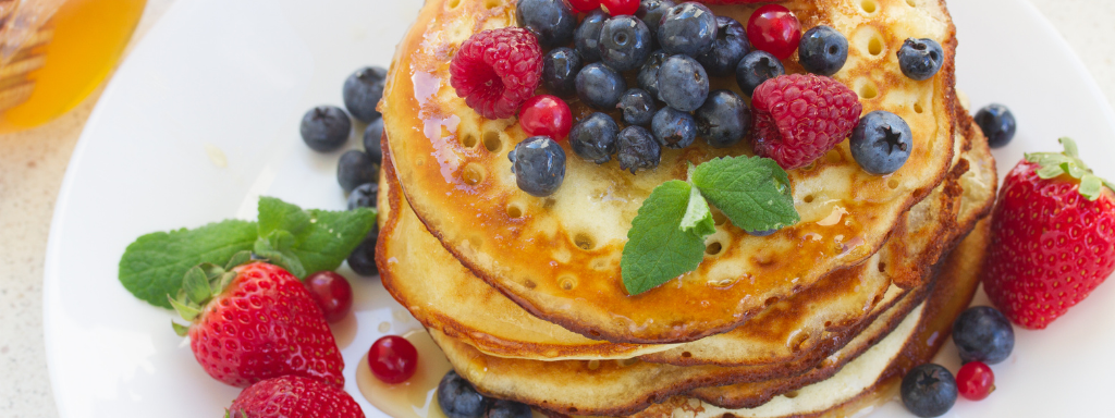 healthy toddler pancake toppings - the photo shows pancakes with mixed fruit including raspberries and blueberries on top