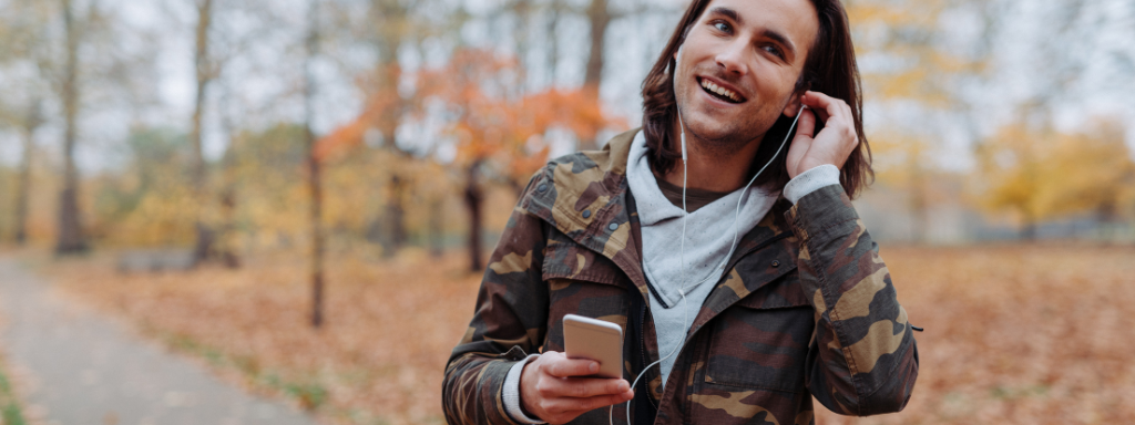 parenting podcasts - the photo shows a man listening to earphones from his phone