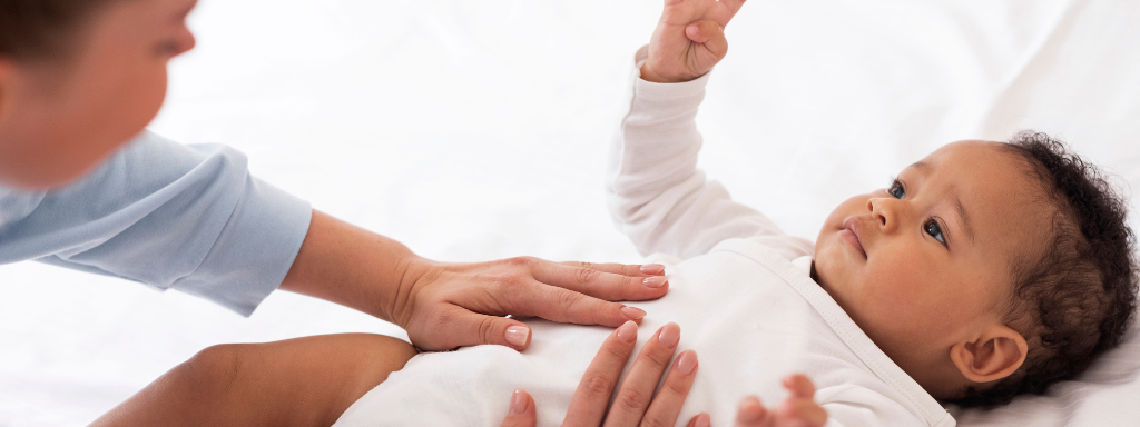 new parent perks and activities - the photo shows a parent massaging a baby's tummy