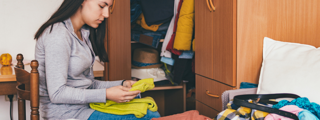 Clear Out Child's Old Clothes - the photo shows a mum sorting through a pile of clothes