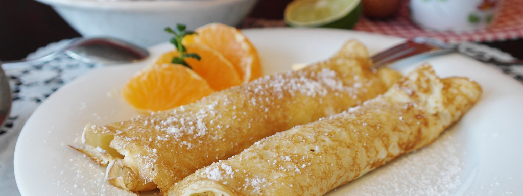 healthy toddler pancake toppings - the photo shows two pancakes on a plate with some orange segments