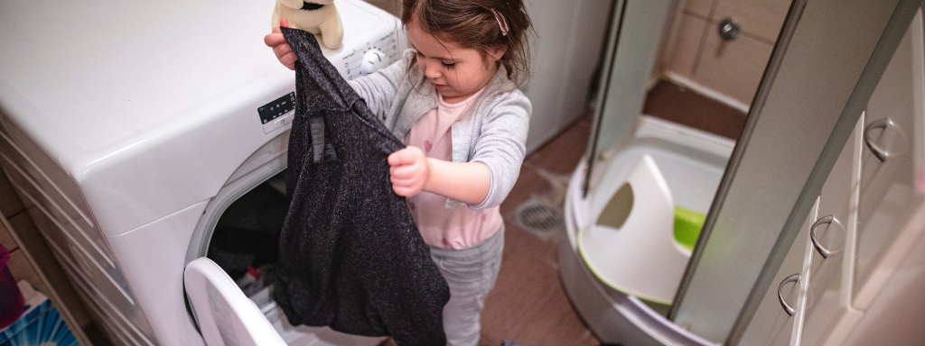 chores for under fives - the photo shows a child unloading the washing machine