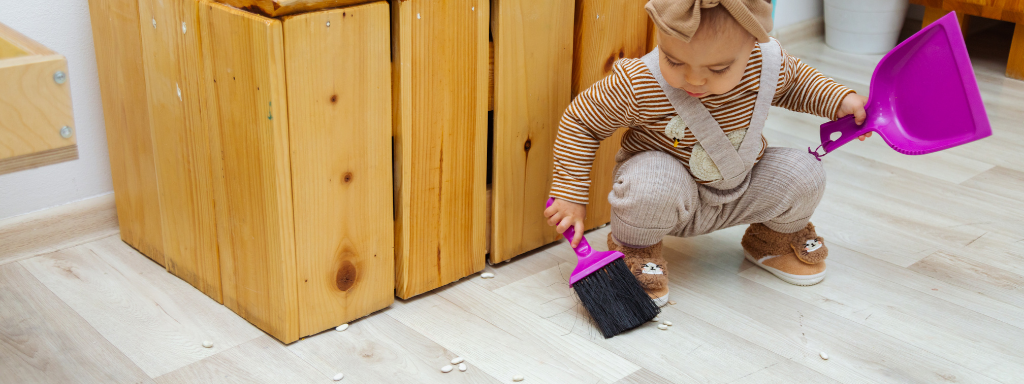 chores for under fives - the image shows a child with dustpan and brush