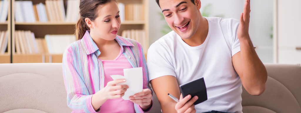 maternity leave checklist  - the photo shows two people discussing money and finances using a calculator