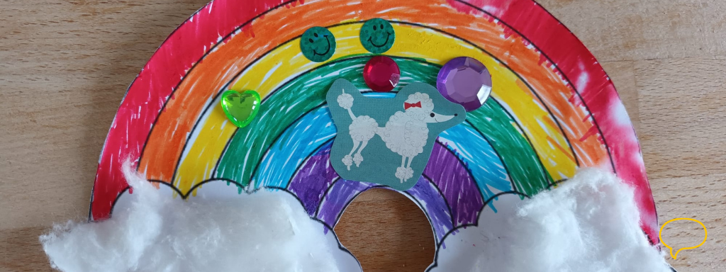 St Patrick's Day toddler crafts - the photo shows a coloured-in rainbow decorated with sequins, stickers and cotton wool