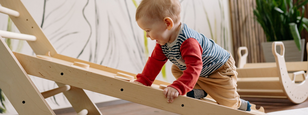 play for early childhood development - the photo shows a toddler crawling up a wooden ramp