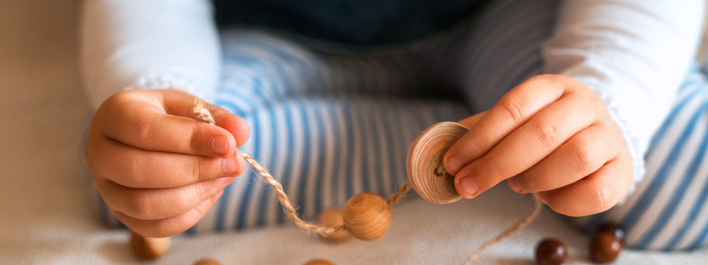 play for early childhood development - the photo shows a child threading beads