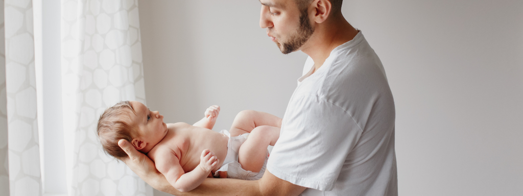 new father nighttime duties - the photo shows a dad cradling a baby